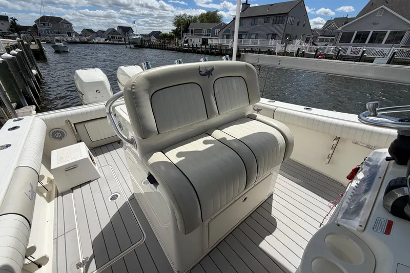 Slide: The Image of 2017 Mako 284 Center Console boat docked, featuring spacious seating and dual outboard engines. - 14