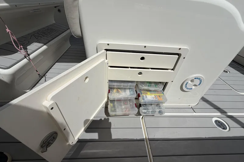 Slide: The Image of Storage compartment on a 2017 Mako 284 Center Console boat with tackle boxes. - 15