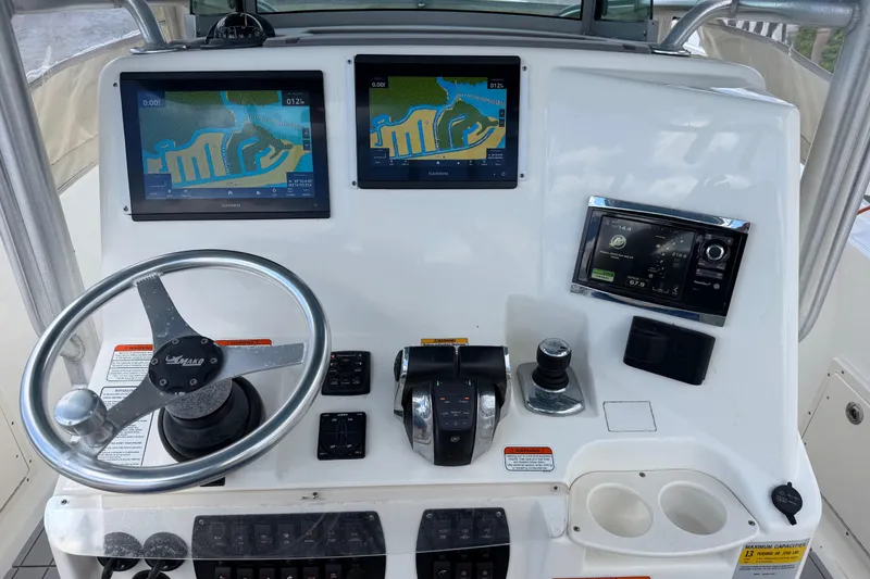 Slide: The Image of 2017 Mako 284 Center Console boat dashboard with navigation screens and controls. - 17