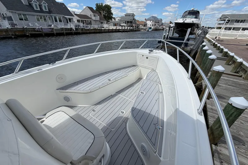 Slide: The Image of 2017 Mako 284 Center Console boat docked by waterfront homes under a blue sky. - 20