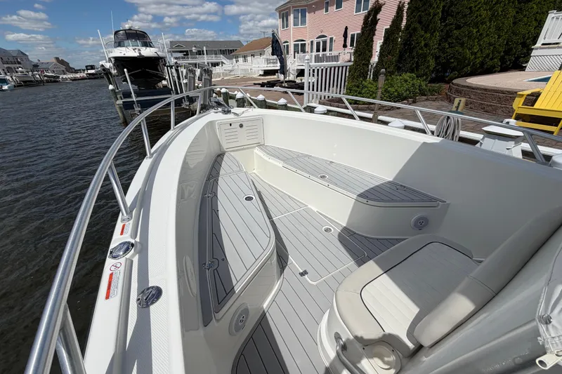 Slide: The Image of 2017 Mako 284 Center Console boat docked, featuring spacious seating and sleek design. - 21