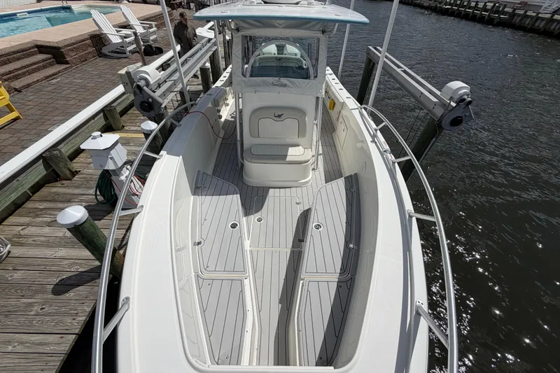 Slide: The Image of 2017 Mako 284 Center Console boat docked by the water. - 22