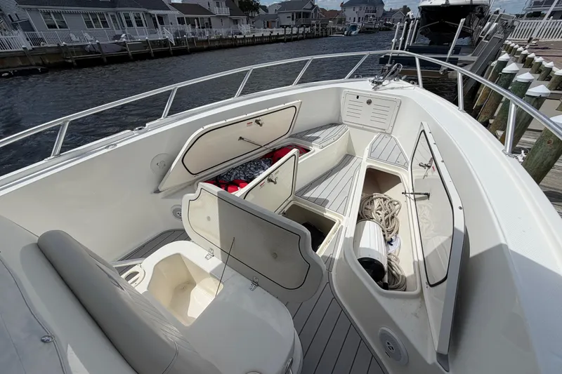 Slide: The Image of 2017 Mako 284 Center Console boat with open storage compartments, docked by waterfront homes. - 25