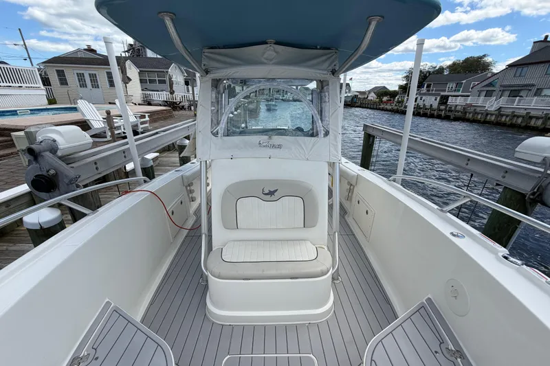 Slide: The Image of 2017 Mako 284 Center Console boat docked by waterfront homes. - 27