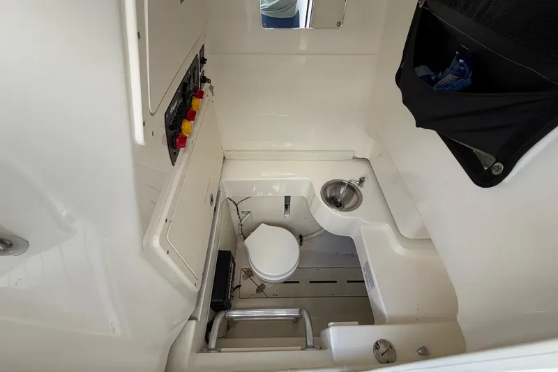 Slide: The Image of Interior of 2017 Mako 284 Center Console boat with toilet and sink. - 29