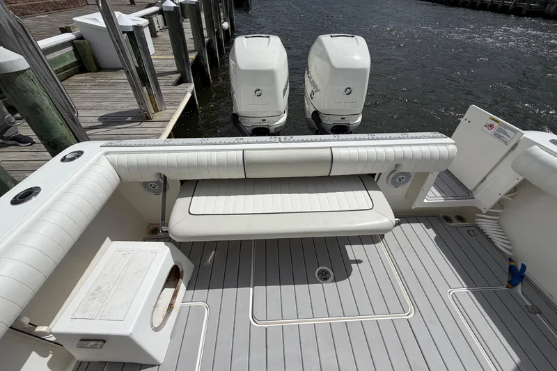 Slide: The Image of 2017 Mako 284 Center Console boat with twin engines docked at a marina. - 31