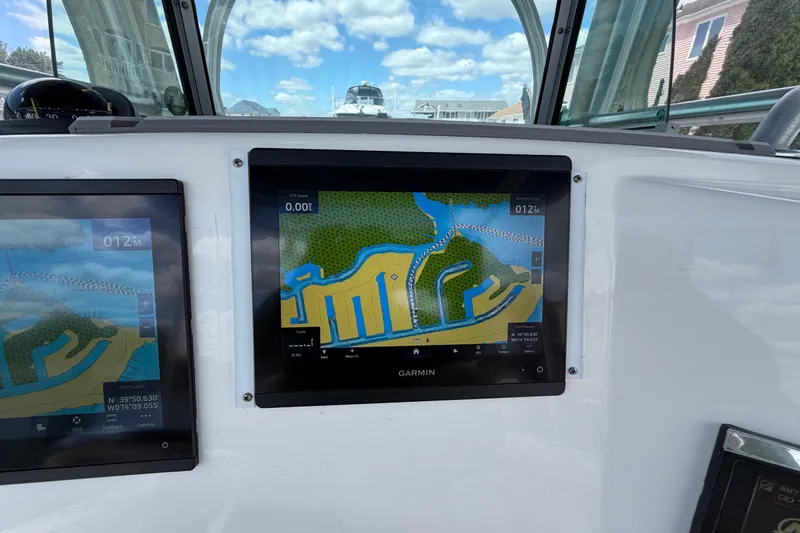 Slide: The Image of Garmin navigation screens on a 2017 Mako 284 Center Console boat, displaying nautical maps. - 37