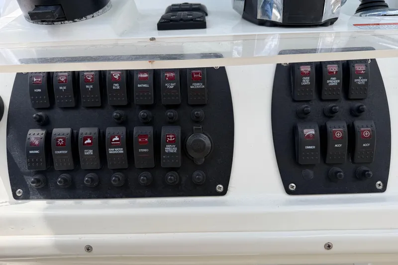 Slide: The Image of Control panel of a 2017 Mako 284 Center Console boat with various switches. - 39