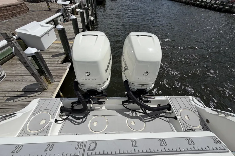 Slide: The Image of 2017 Mako 284 Center Console boat with twin outboard engines docked by the water. - 5