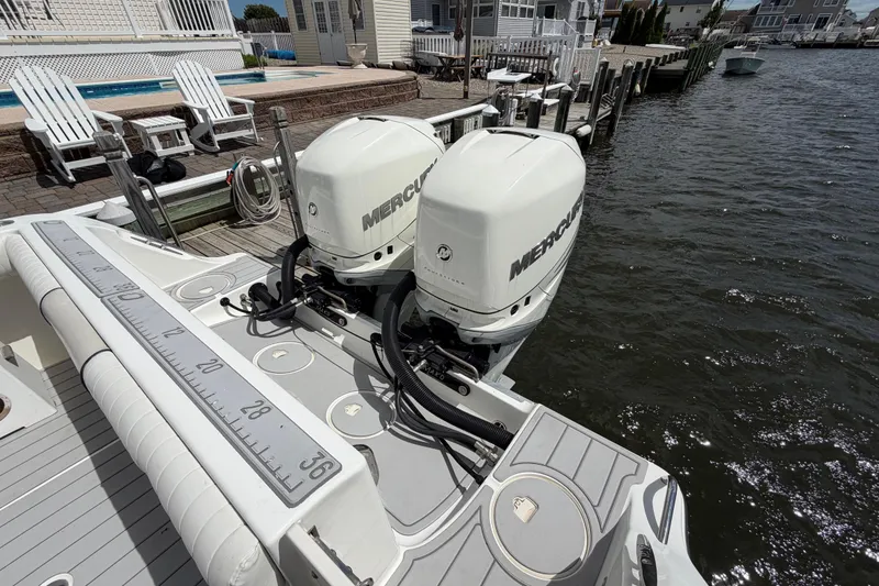 Slide: The Image of 2017 Mako 284 Center Console boat with dual Mercury outboard engines docked by waterfront. - 6