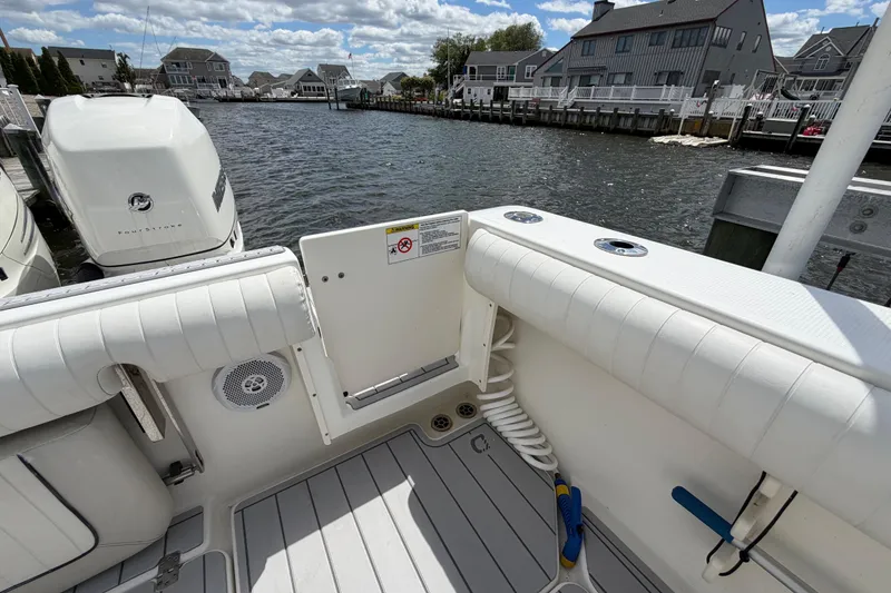 Slide: The Image of 2017 Mako 284 Center Console boat docked, featuring spacious deck and powerful outboard engines. - 7