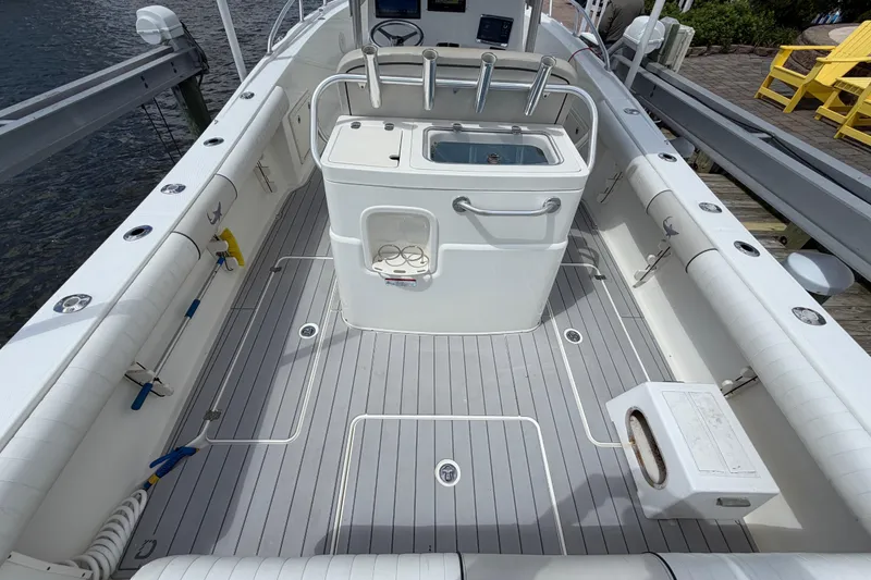 Slide: The Image of 2017 Mako 284 Center Console boat interior with fishing rod holders and storage compartments. - 9