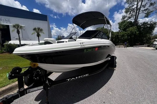 Slide: The Image of 2022 Tahoe 185 S boat on trailer, parked outdoors under a sunny sky. - 2