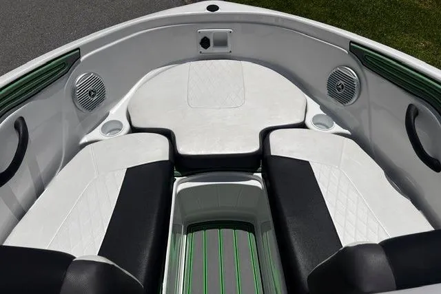 Slide: The Image of 2022 Tahoe 185 S boat interior with white and black seating, green accents, and speakers. - 22