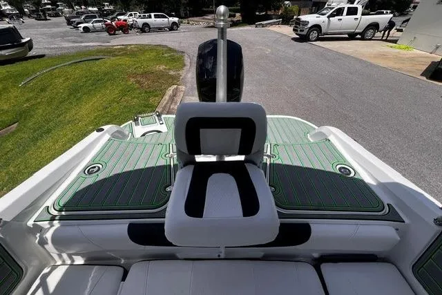 Slide: The Image of 2022 Tahoe 185 S boat interior with green accents and seating, parked outdoors. - 24