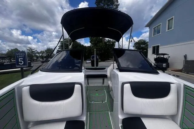 Slide: The Image of 2022 Tahoe 185 S boat interior with black and white seating, under a cloudy sky. - 9
