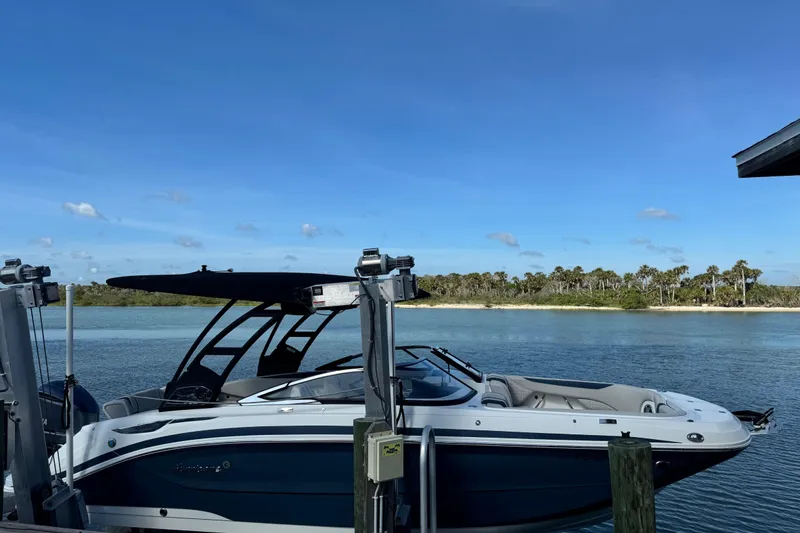 The Image of 2023 Hurricane SunDeck 2600 OB boat docked by a scenic shoreline. - 0