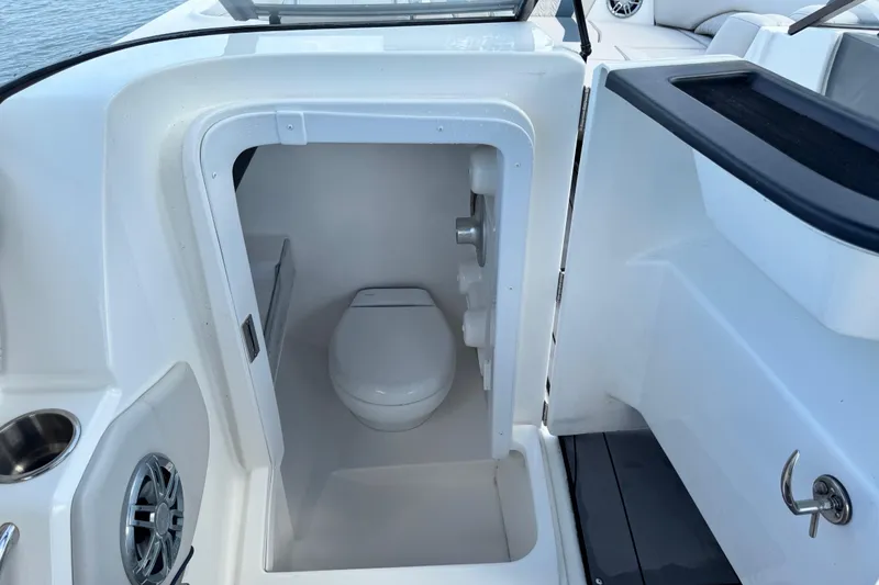 Slide: The Image of 2023 Hurricane SunDeck 2600 OB boat interior with compact marine toilet. - 1