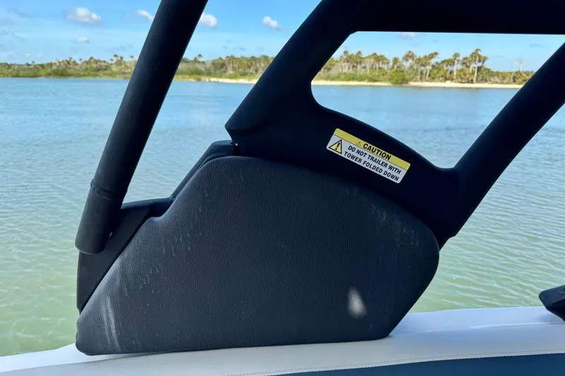Slide: The Image of 2023 Hurricane SunDeck 2600 OB boat detail with caution label, scenic water view. - 10