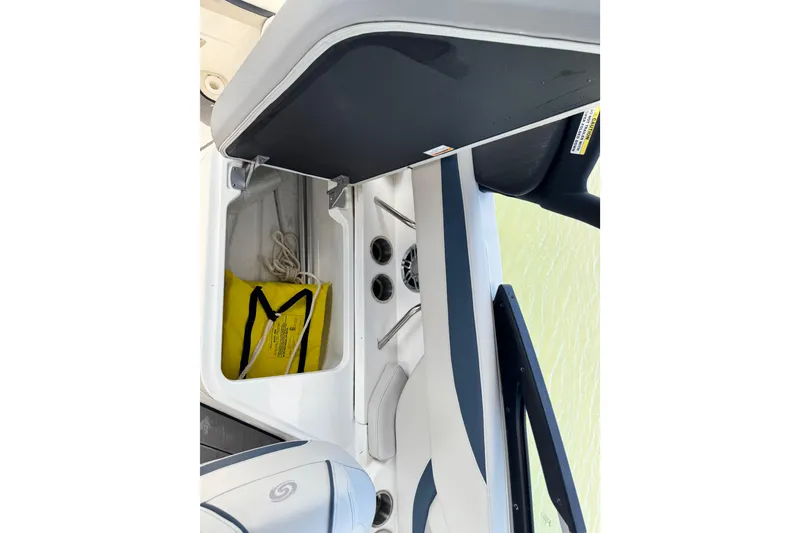 Slide: The Image of 2023 Hurricane SunDeck 2600 OB boat storage compartment with yellow bag and rope. - 12