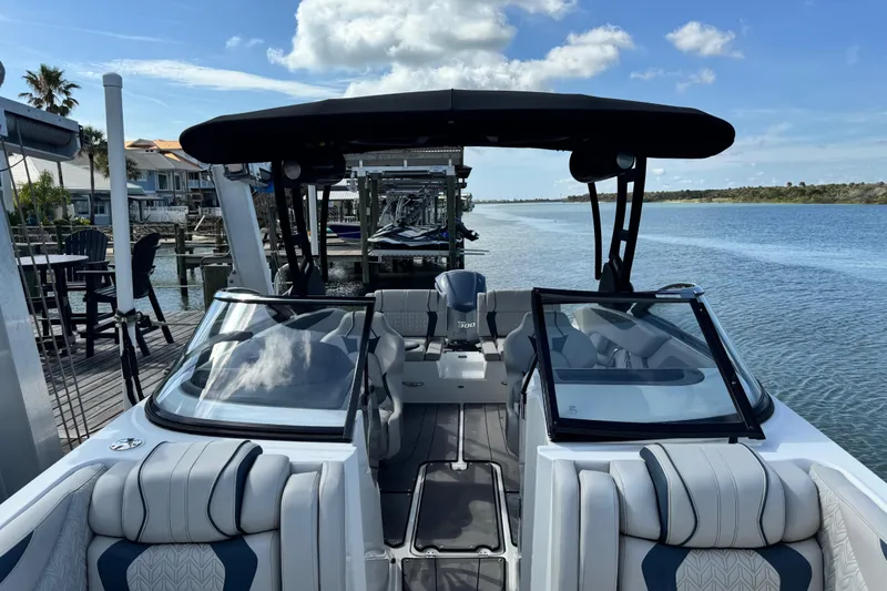 Slide: The Image of 2023 Hurricane SunDeck 2600 OB boat docked by a scenic waterfront. - 17