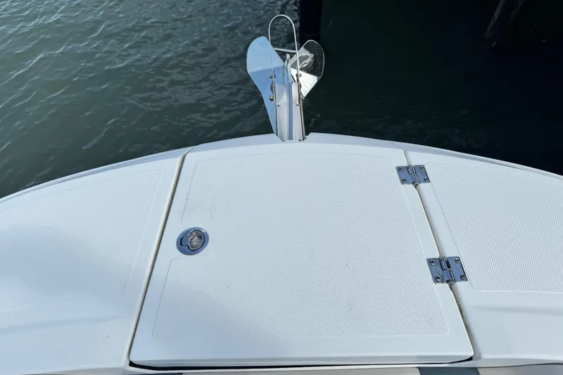 Slide: The Image of 2023 Hurricane SunDeck 2600 OB boat deck with anchor, docked on water. - 19