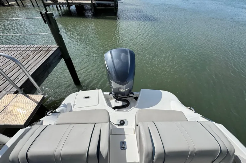 Slide: The Image of 2023 Hurricane SunDeck 2600 OB boat with outboard motor docked by wooden pier. - 9