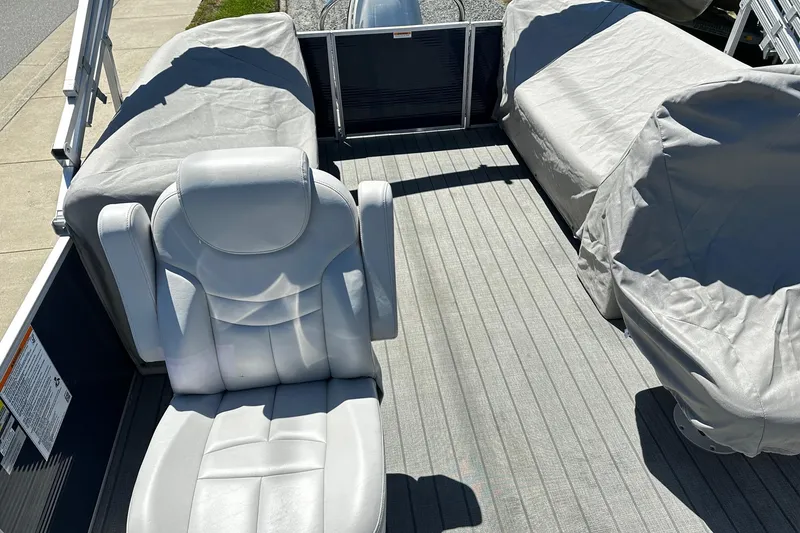 Slide: The Image of 2023 Godfrey Sweetwater 2286 SB boat interior with covered seating and captain's chair. - 6