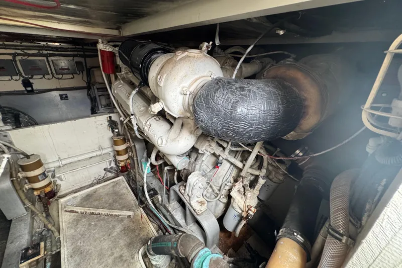 Slide: The Image of Engine room of a 1988 Bertram 50 Convertible, showcasing mechanical components and piping. - 16