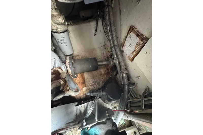 Slide: The Image of Engine room of 1988 Bertram 50 Convertible with visible pipes and cables. - 17