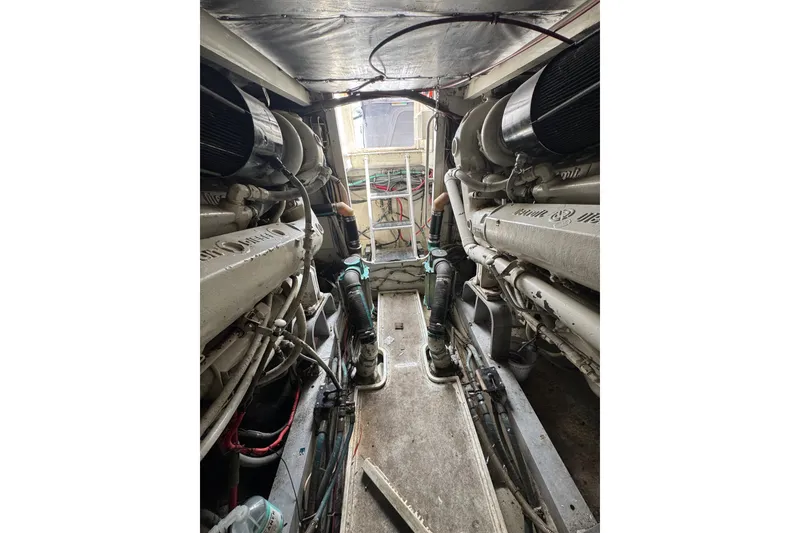Slide: The Image of Engine room of a 1988 Bertram 50 Convertible yacht, showcasing dual engines and mechanical components. - 18