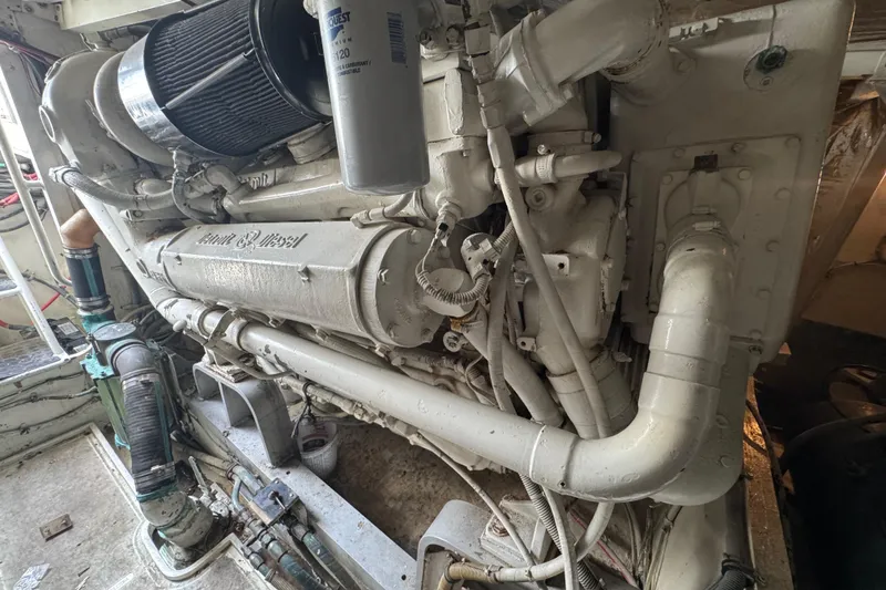 Slide: The Image of Engine room of a 1988 Bertram 50 Convertible yacht, showcasing a powerful marine diesel engine. - 20