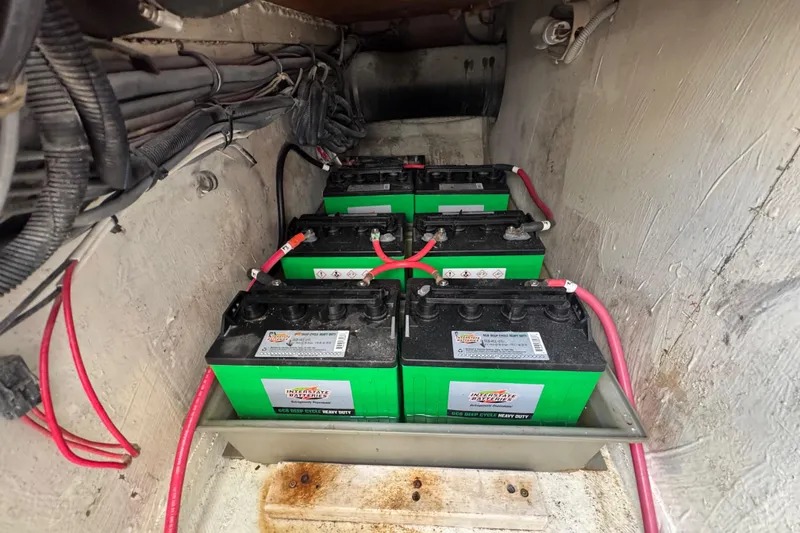 Slide: The Image of Battery compartment of a 1988 Bertram 50 Convertible with four green batteries and red cables. - 24