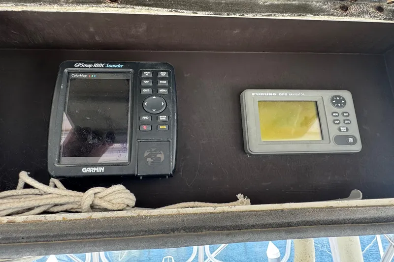Slide: The Image of Garmin and Furuno GPS devices on a 1988 Bertram 50 Convertible boat dashboard. - 32