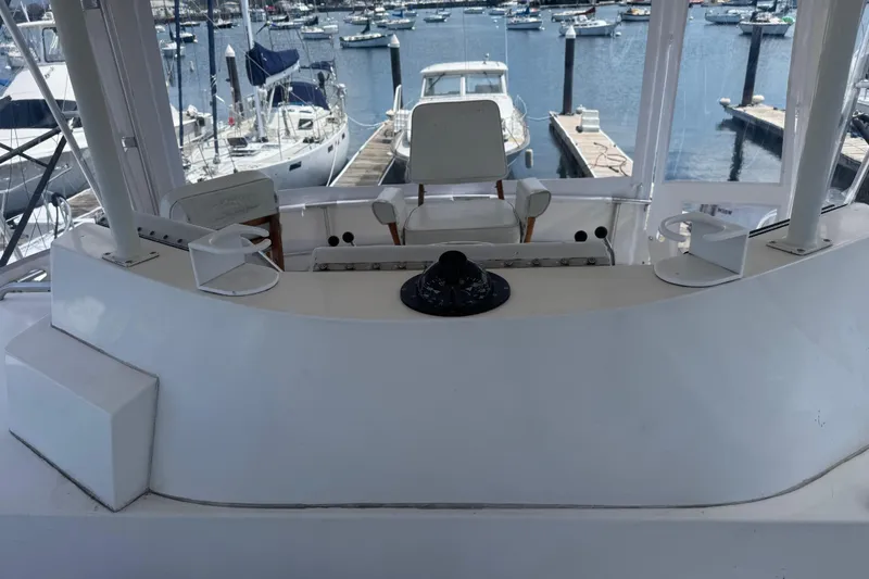 Slide: The Image of Helm of 1988 Bertram 50 Convertible yacht at marina, showcasing controls and seating. - 34