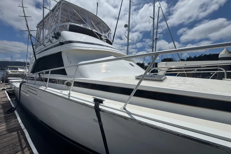 Slide: The Image of 1988 Bertram 50 Convertible yacht docked under a partly cloudy sky. - 4