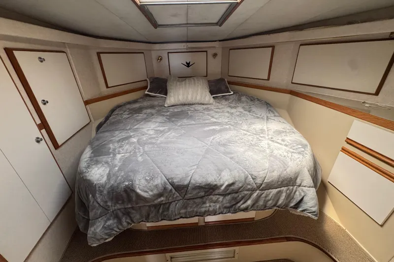 Slide: The Image of Cozy bedroom interior of 1988 Bertram 50 Convertible yacht with plush bedding. - 48