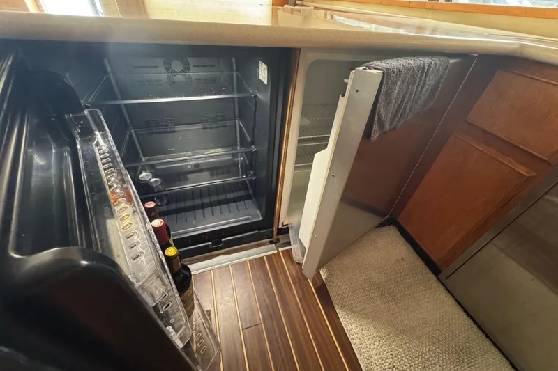 Slide: The Image of Interior of 1988 Bertram 50 Convertible showing open fridge with wine bottles. - 51