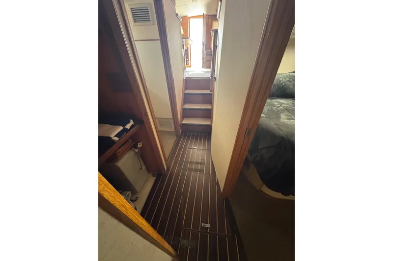 Slide: The Image of Interior hallway of a 1988 Bertram 50 Convertible yacht with wooden flooring. - 53