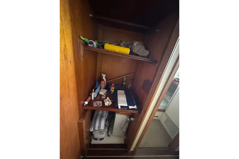 Slide: The Image of Interior storage of 1988 Bertram 50 Convertible boat with shelves and various items. - 54
