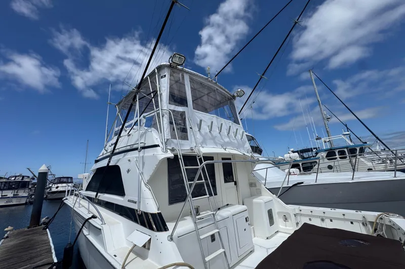 Slide: The Image of 1988 Bertram 50 Convertible yacht docked under a clear blue sky. - 8