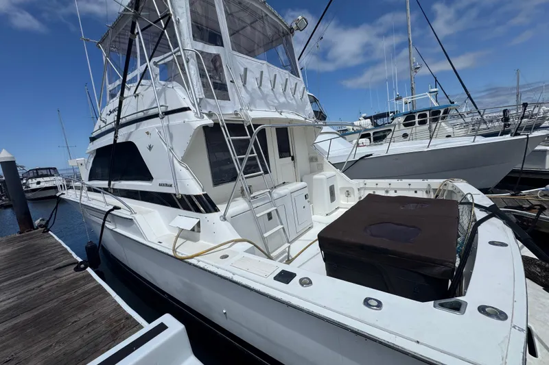 Slide: The Image of 1988 Bertram 50 Convertible yacht docked at marina under clear blue sky. - 9