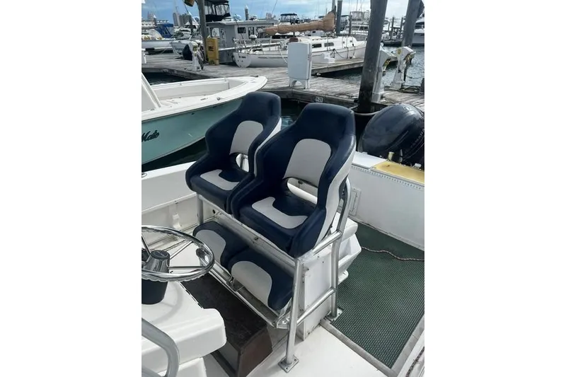 Slide: The Image of 2001 Sea Pro 255 Center Console boat with dual navy and white seats at marina. - 3