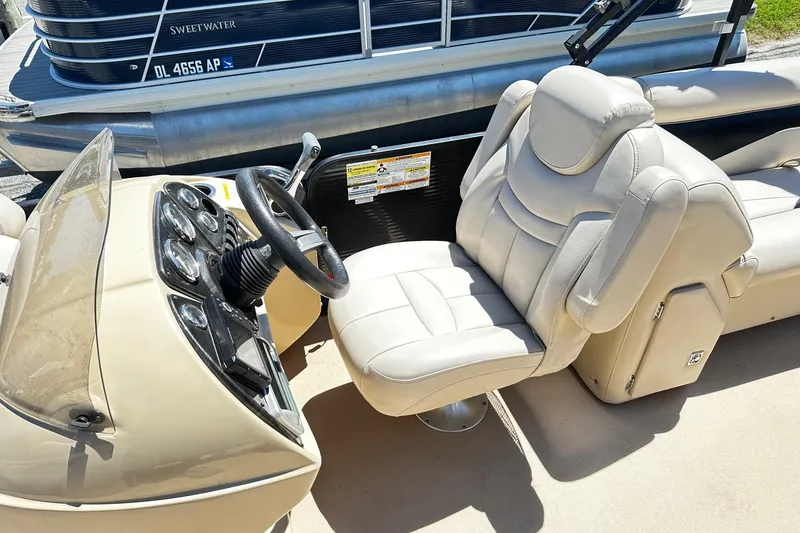 Slide: The Image of 2016 Godfrey Sweetwater 2286SB boat interior with steering wheel and plush captain's chair. - 5