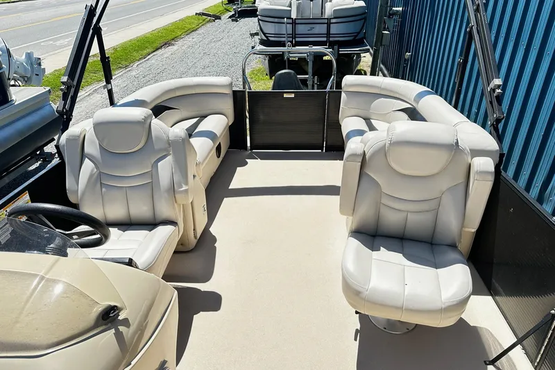 Slide: The Image of 2016 Godfrey Sweetwater 2286SB pontoon boat interior with plush seating and steering console. - 6