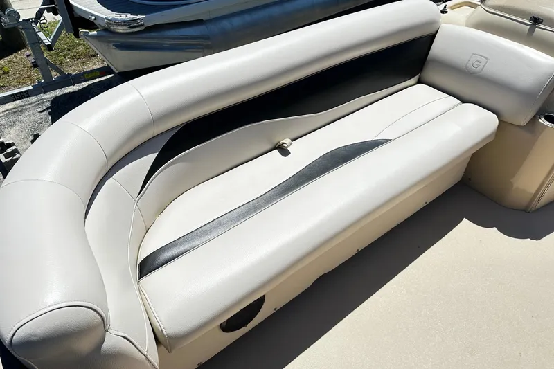 Slide: The Image of 2016 Godfrey Sweetwater 2286SB boat interior with beige and black cushioned seating. - 9