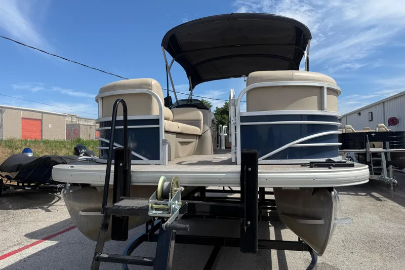 Slide: The Image of 2021 Sun Tracker SportFish 22 DLX pontoon boat on trailer, outdoor setting. - 15