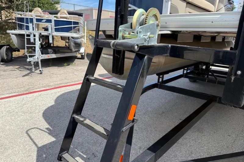 Slide: The Image of 2021 Sun Tracker SportFish 22 DLX on trailer with ladder and winch mechanism. - 16