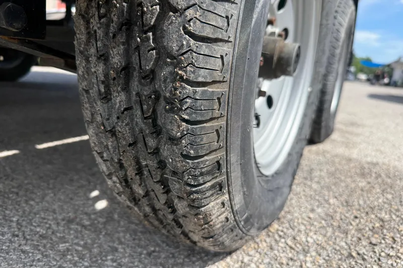 Slide: The Image of Close-up of a 2021 Sun Tracker SportFish 22 DLX trailer tire on pavement. - 18