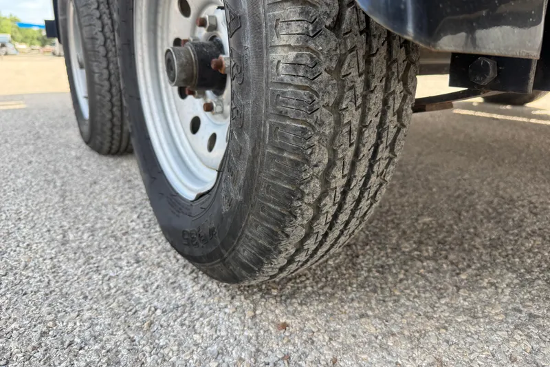 Slide: The Image of Close-up of a 2021 Sun Tracker SportFish 22 DLX trailer tire on asphalt. - 23